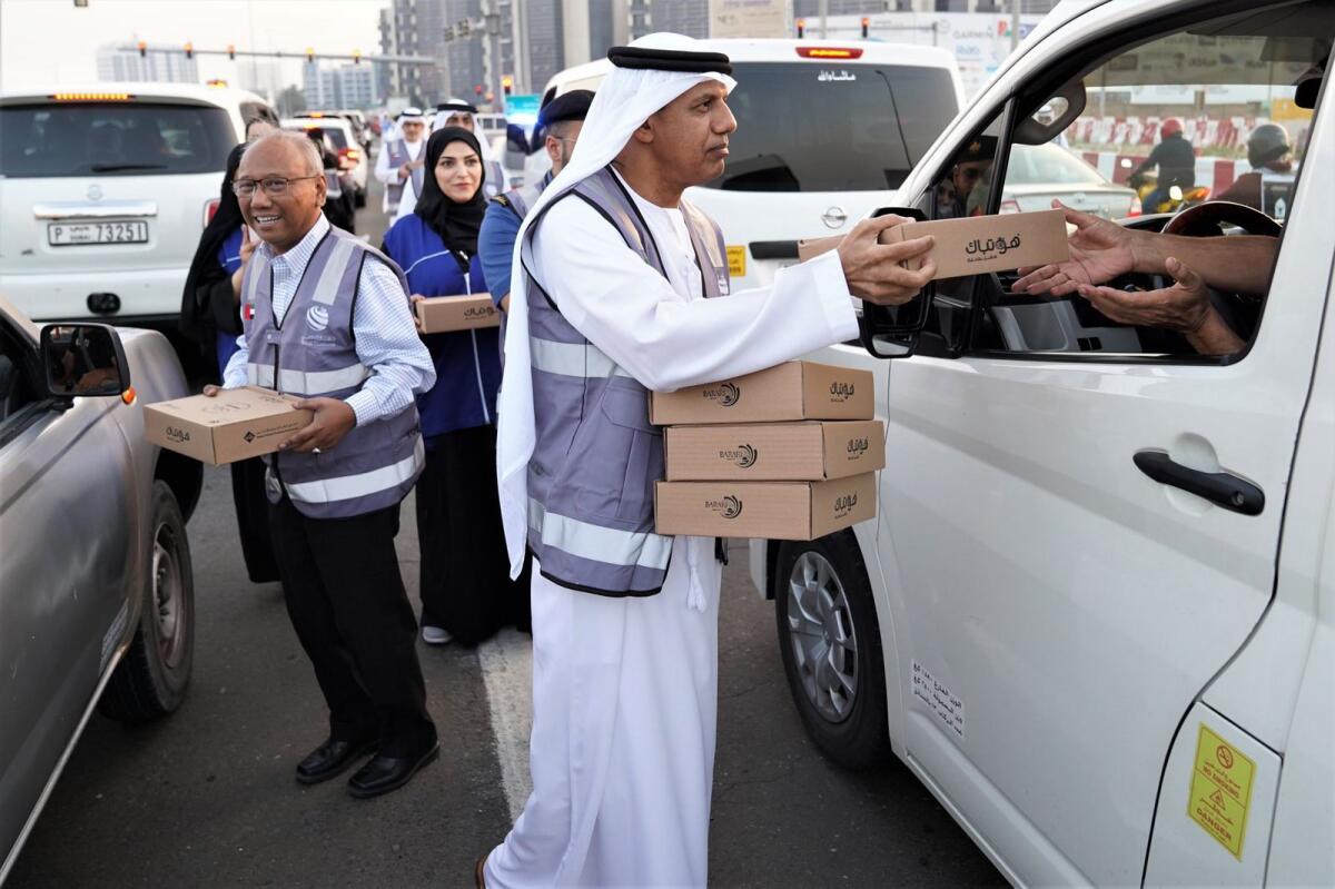 Dubai Customs volunteers hand out kits on the road