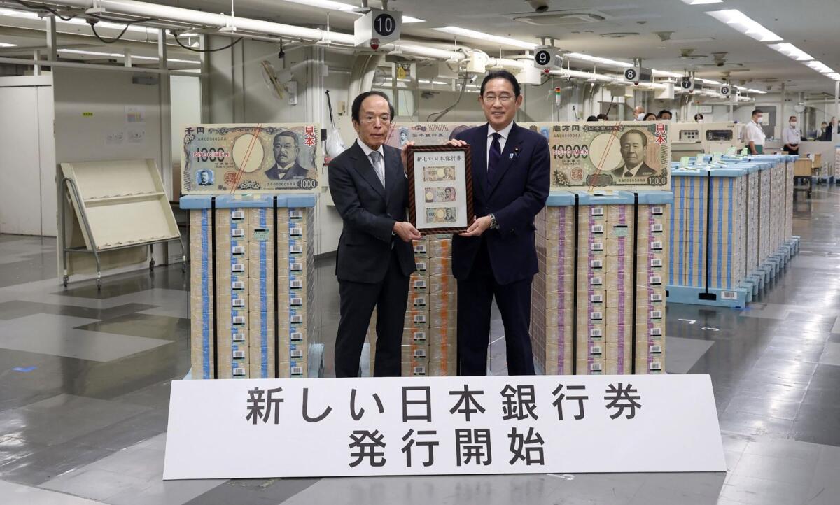 Japan's Prime Minister Fumio Kishida (R) poses for a commemorative photo with Bank of Japan Governor Kazuo Ueda at the Bank of Japan headquarters in Tokyo on Tuesday to mark the issuance of new yen banknotes. – AFP