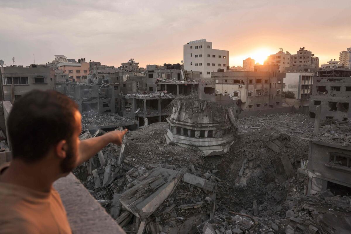 A Palestinian points to the Ahmed Yassin mosque, which was levelled by Israeli airstrikes, in Gaza City early on October 9, 2023. Photo: AFP