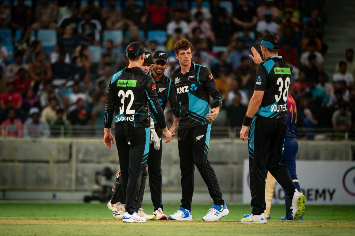 New Zealand's Mitchell Santner celebrates a wicket with teammates.