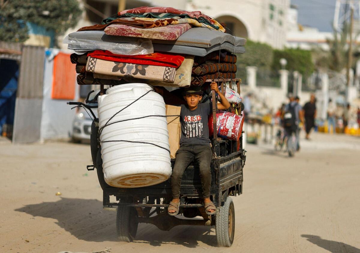A Palestinian boy, who fled the eastern part of Khan Younis after they were ordered by Israeli army to evacuate their neighbourhoods, rides on a vehicle loaded with belongings in Khan Younis on Tuesday. — Reuters