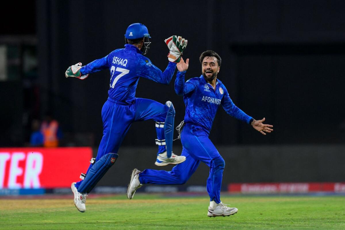 Afghanistan's captain Rashid Khan (right) celebrates a wicket with a teammate during the match against Bangladesh. — AFP
