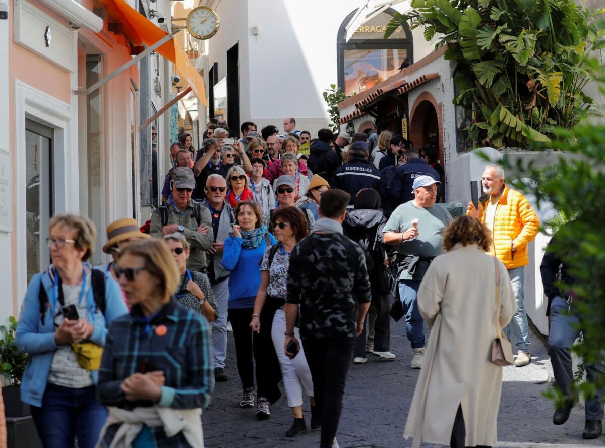 People walk in the street on Capri Island, Italy, on April 18, 2024. — Reuters