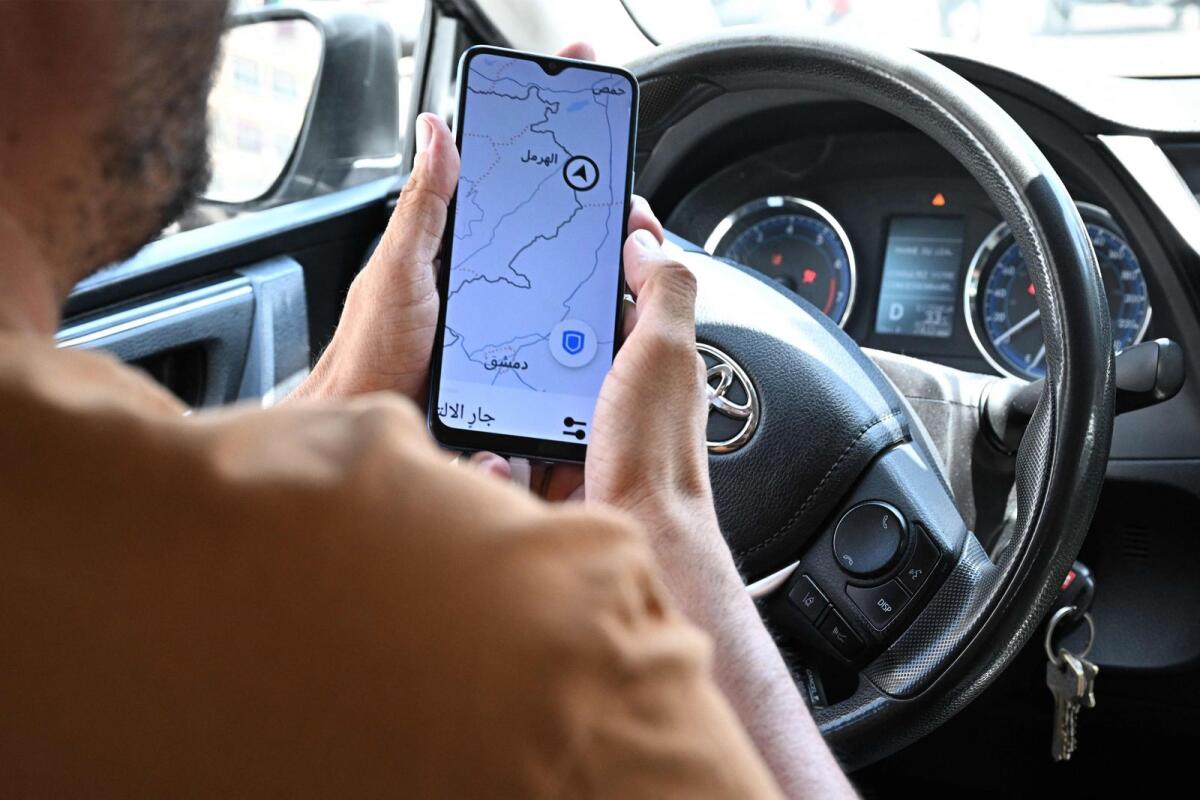 Lebanese Uber driver Hussein Khalil shows his GPS jammed geolocation on the Uber application showing the area of Hermel in Lebanon's eastern Bekaa valley, as he sits in his vehicle in Beirut's Hamra street on June 11, 2024. — AFP