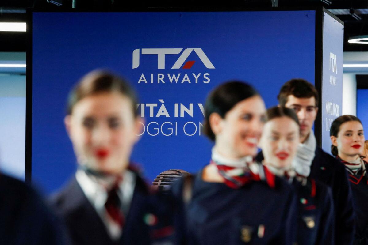 Cabin crew members, wearing uniforms designed by Brunello Cucinelli, welcome guests during a presentation of a new Airbus A320neo aircraft of Italia Trasporto Aereo (ITA Airways), at Fiumicino airport in Rome, Italy, on April 19, 2023. — Reuters