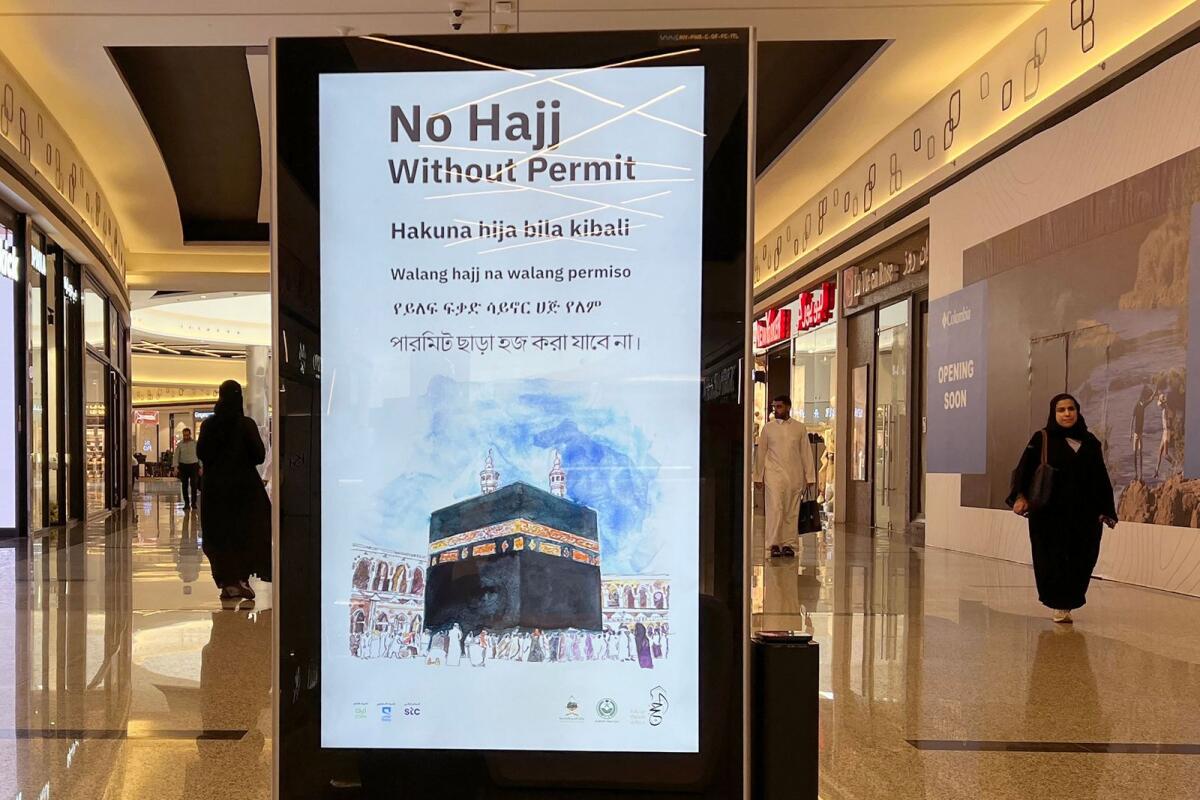 Women walk next to a billboard, highlighting the importance of a permit to perform pilgrimage, at a mall in Riyadh on June 3, 2024, ahead of the annual the Haj pilgrimage.  — AFP