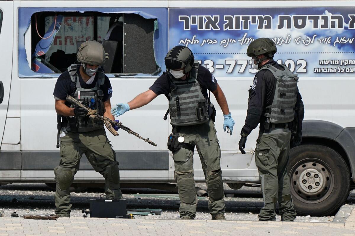 Israeli police retrieve weapons used by militants outside a police station that was overrun by Hamas gunmen on Saturday, in Sderot, Israel, Sunday, Oct.8, 2023. Photo: AP