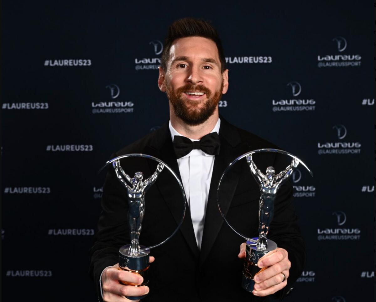 Lionel Messi smiles after receiving the trophies. — Twitter