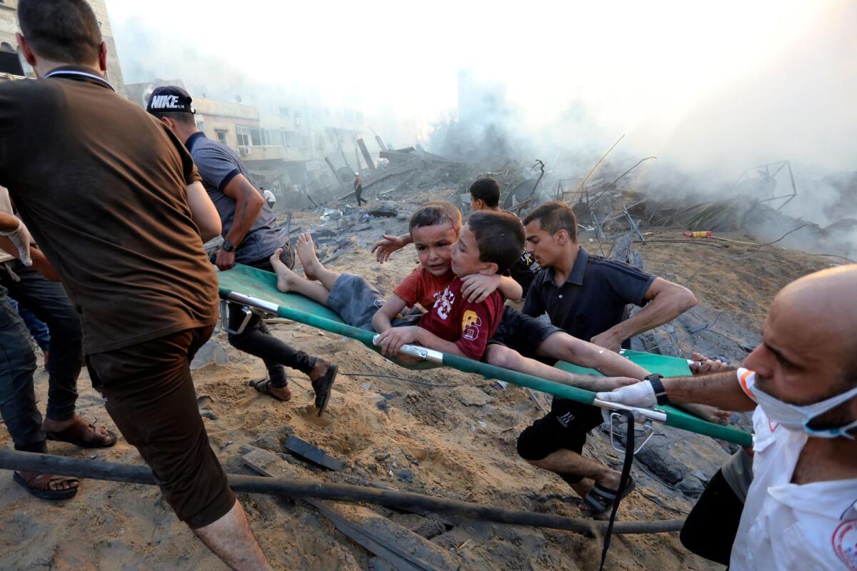 Palestinians evacuate two wounded boys out of the destruction following Israeli airstrikes on Gaza City, Wednesday, Oct. 25, 2023.Photo: AP