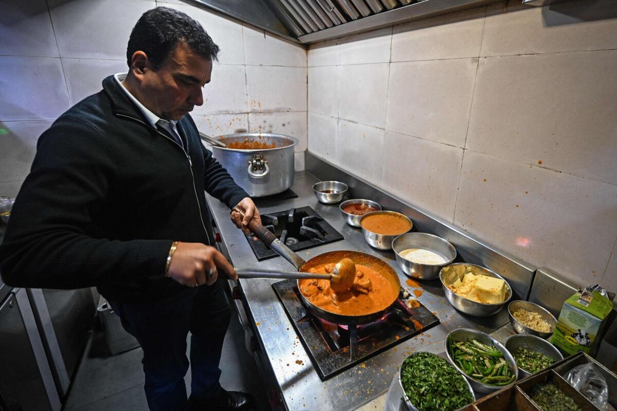 Monish Gujral, the owner of Moti Mahal, prepares butter chicken at his restaurant. Photo: AFP file