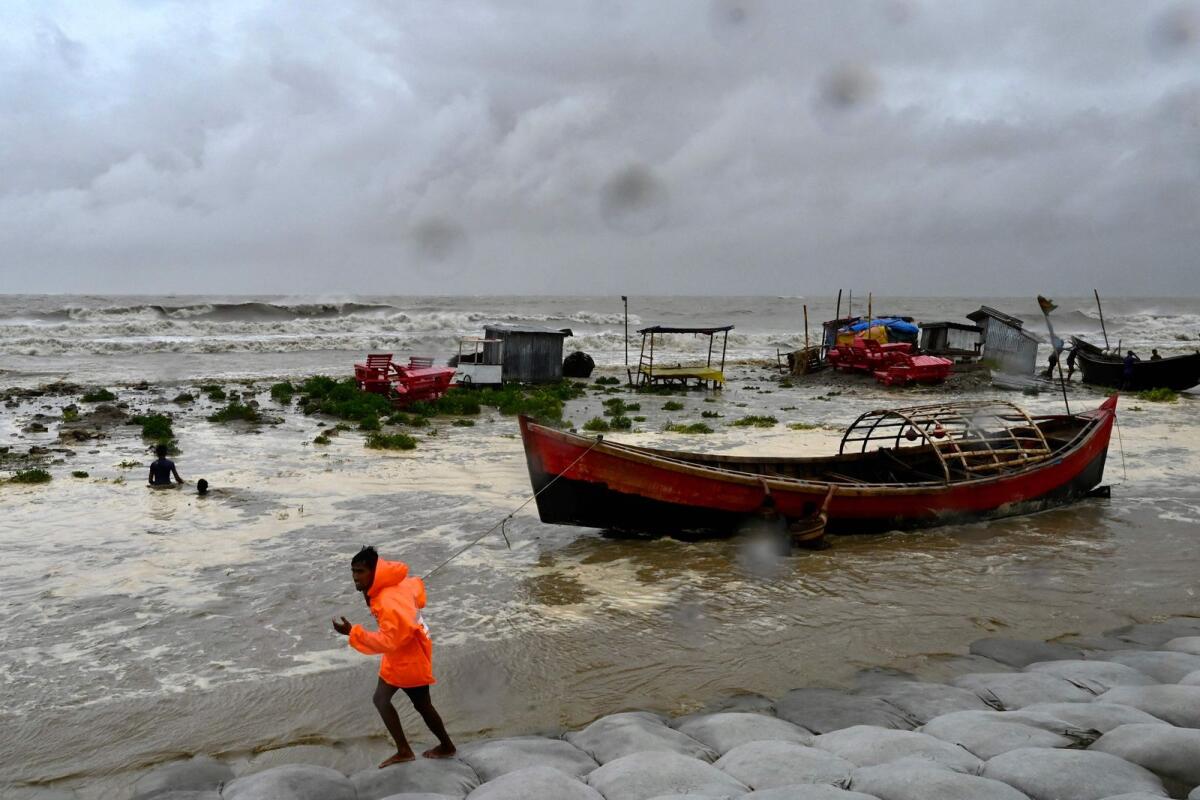 A man pulls a fishing boat to a sea shore in Kuakata ahead of cyclone Remal's landfall in Bangladesh. Photo: AFP