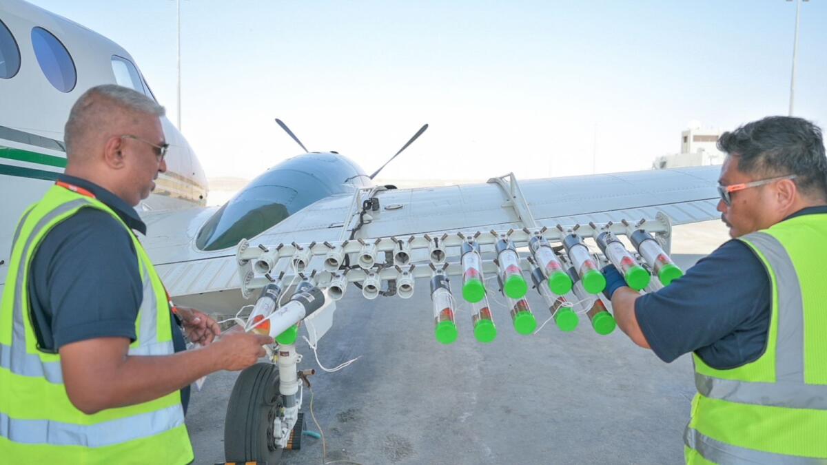 Technician attaching Hygroscopic (water-attracting) salt flares to an aircraft at Al Ain International Airport before a cloud-seeding on 12th Oct 2023. Photo: Rahul Gajjar