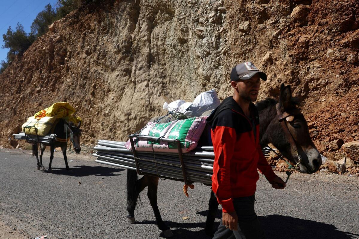 A man walks with donkeys that are loaded with aid to carry up to villages that rescue workers and aid can't reach due to conditions of the roads, in the aftermath of a deadly earthquake near the rural village of Agndiz, Morocco, on Wednesday. — Reuters