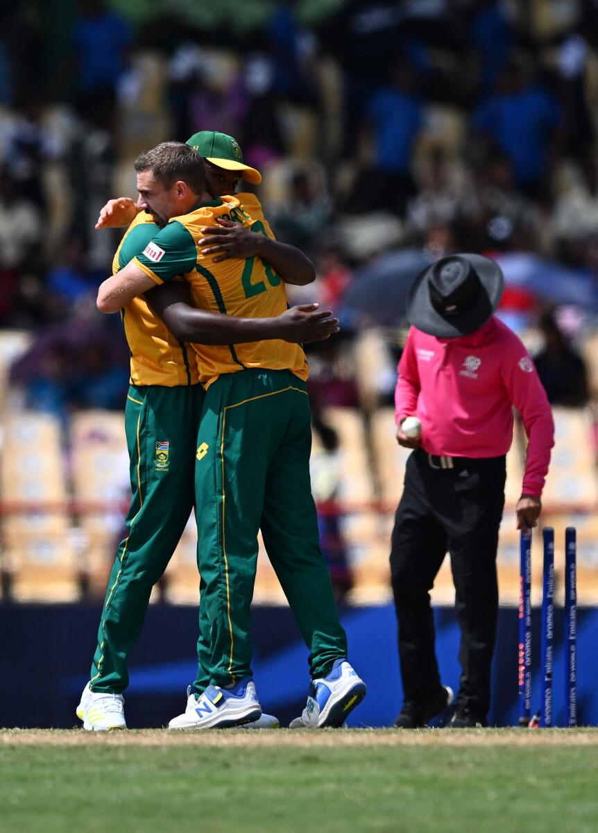 Kagiso Rabada embraces teammate Anrich Nortje after South Africa beat England. — AFP