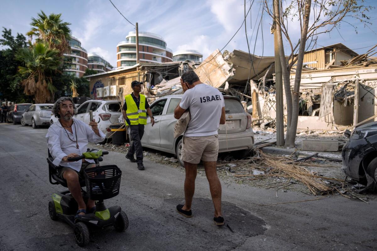 Israelis inspect the rubble of a building a day after it was hit by a rocket fired from the Gaza Strip, in Tel Aviv, Israel, Sunday, Oct. 8, 2023. Photo: AP