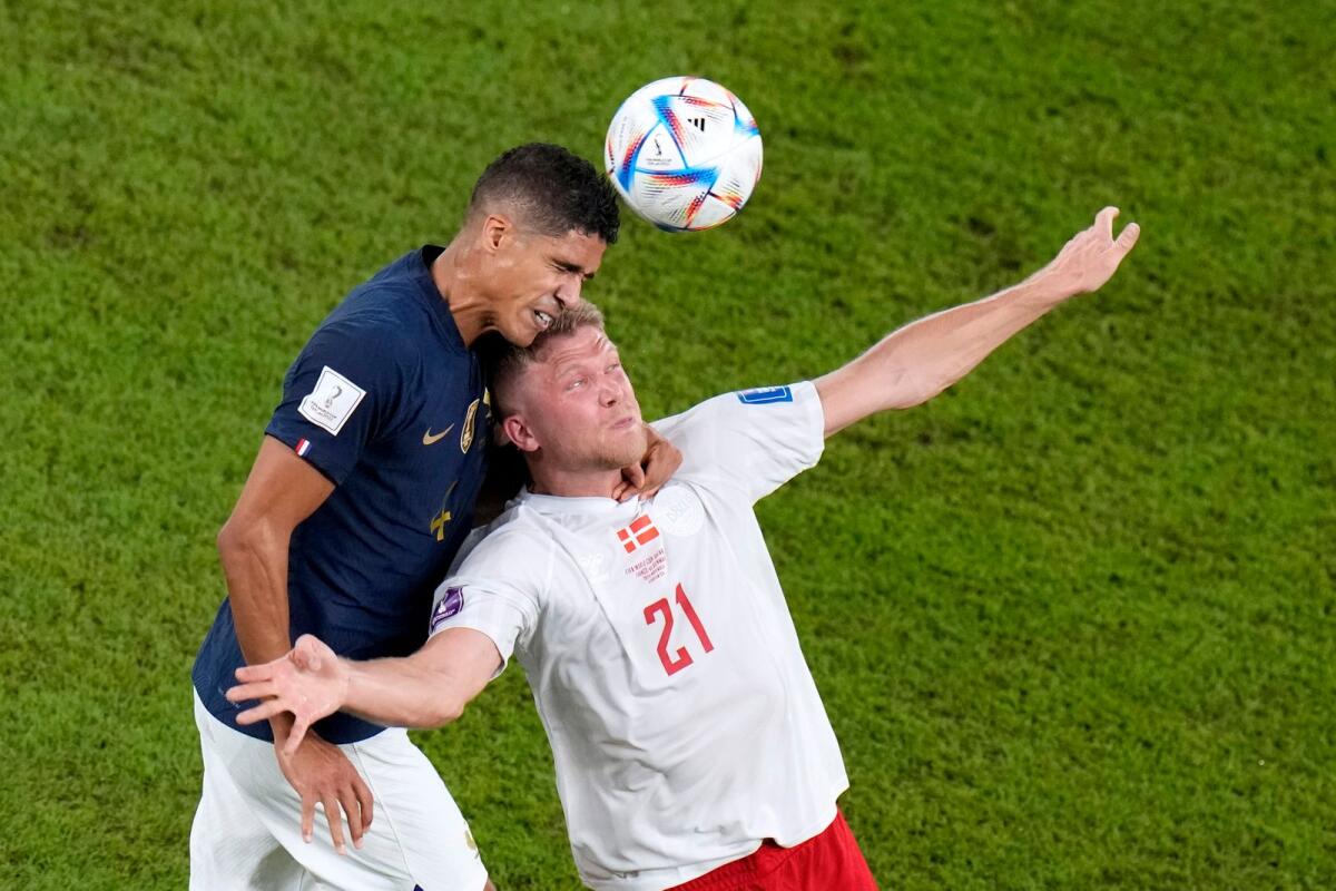 France's Raphael Varane, and Denmark's Andreas Cornelius go for a header during the 2022 World Cup match at the Stadium 974 in Doha, Qatar.  — AP