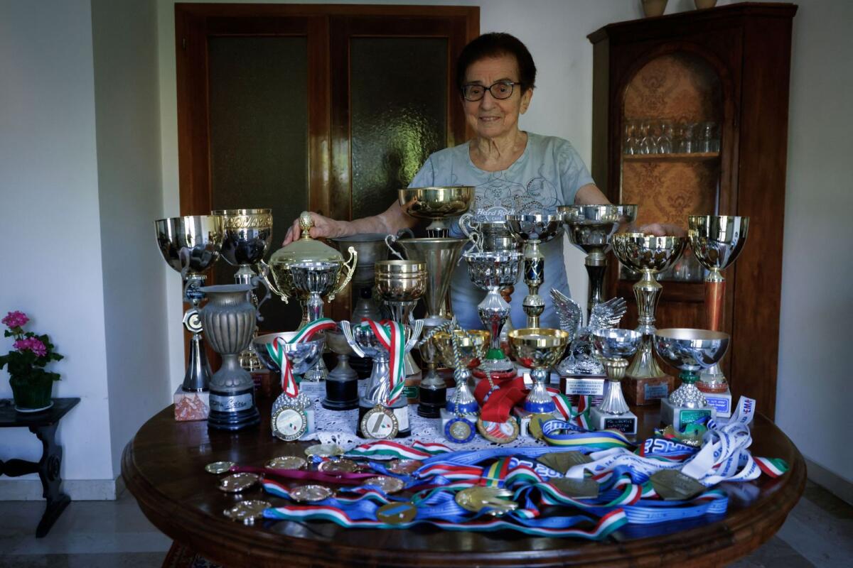 Italian master runner Emma Maria Mazzenga, 90, poses for a picture with some of her trophies, at home in Padua, Italy, on May 5, 2024. — Reuters