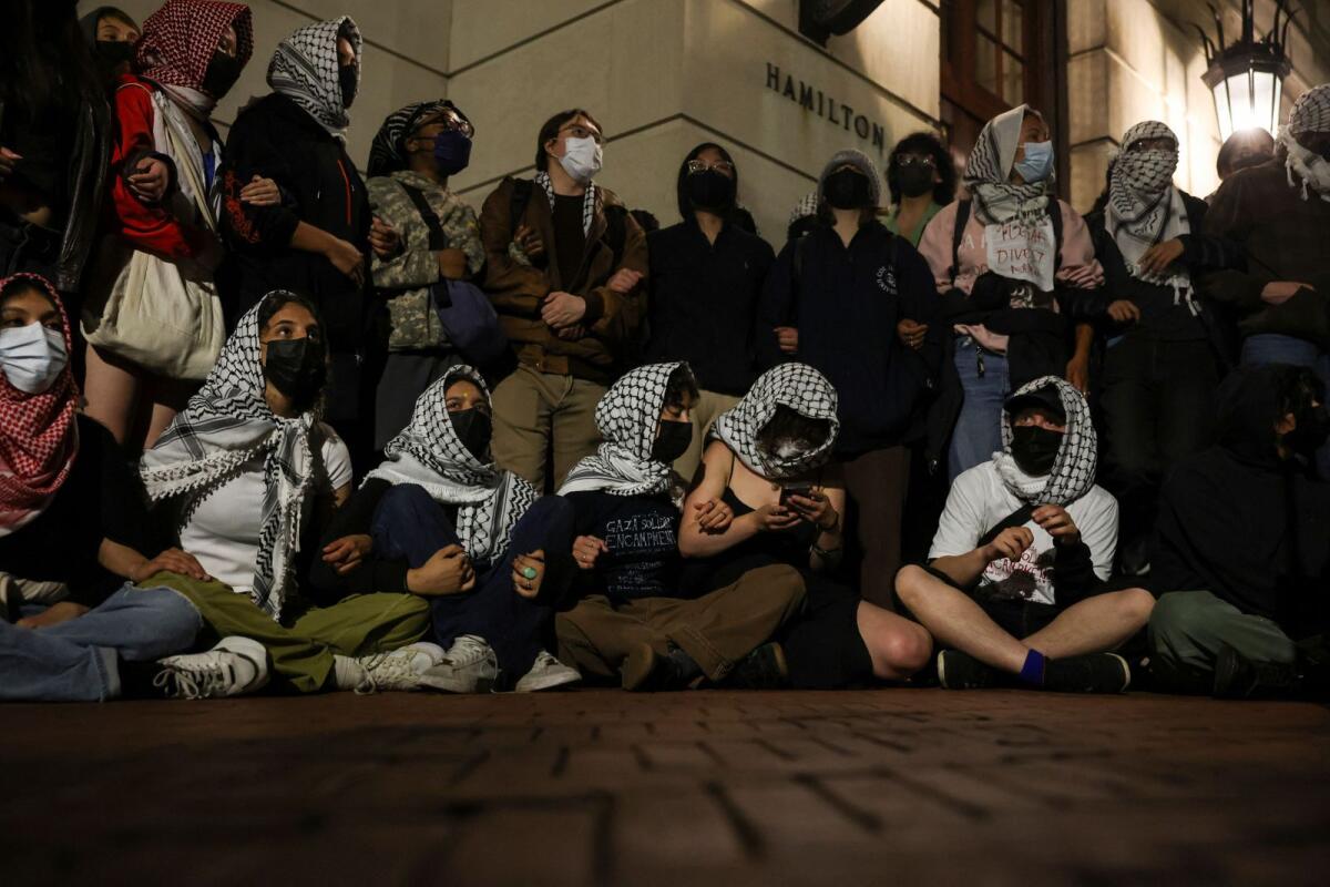 Protesters link arms outside Hamilton Hall barricading students inside the building at Columbia University, in New York City, US. Photo: Reuters