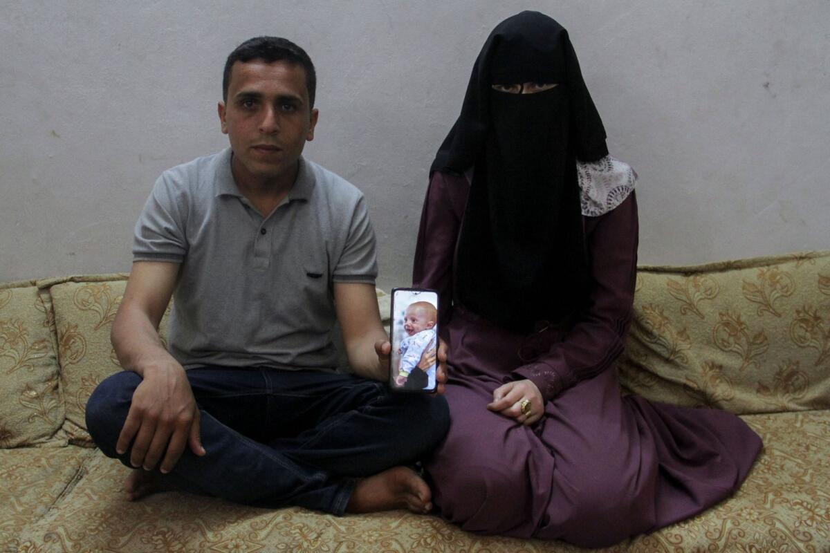 Zakaria Hamuda and his wife Sondos, parents of Palestinian infant Yehia, who was evacuated to south Gaza as a premature baby after Israeli forces raided Kamal Adwan hospital in northern Gaza Strip and is currently separated from his parents due to an Israeli checkpoint that separates north Gaza from the south, display a picture of him on a mobile phone in Jabalia in the northern Gaza Strip on April 25. — Reuters