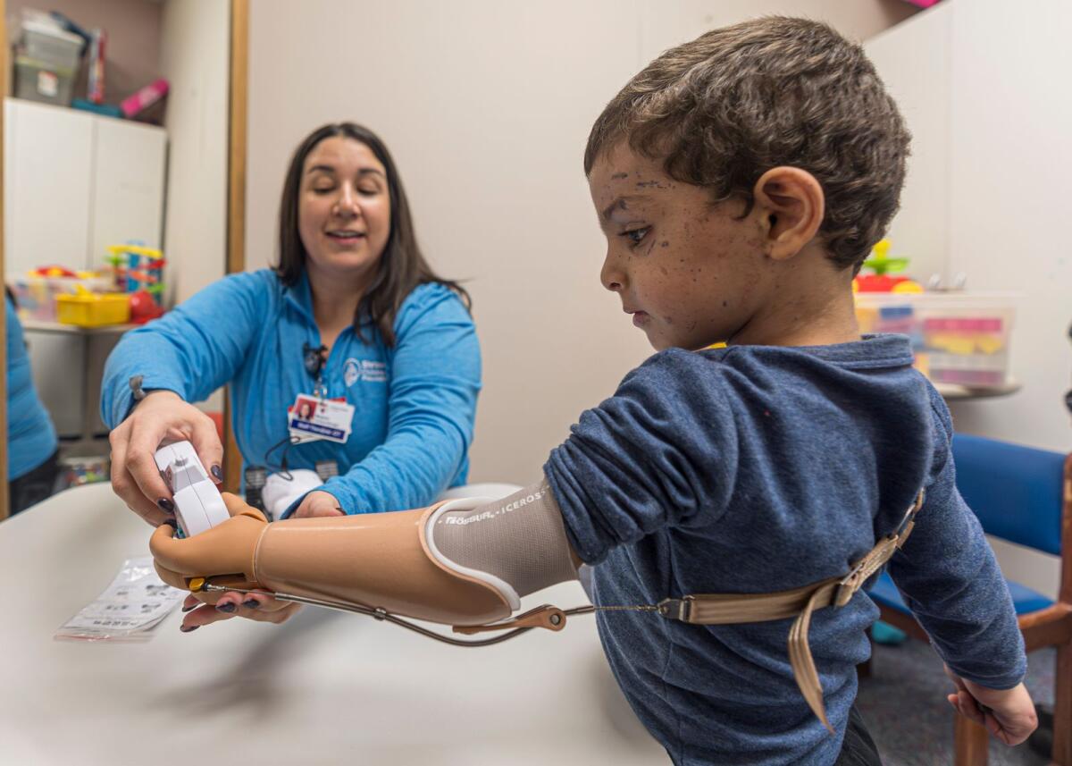Four-year-old Omar Abu Kuwaik learns to use his new prosthetic arm with occupational therapist Meghan Gossenberger at Shriners Children's Hospital on Feb. 28, 2024 in Philadelphia. — AP