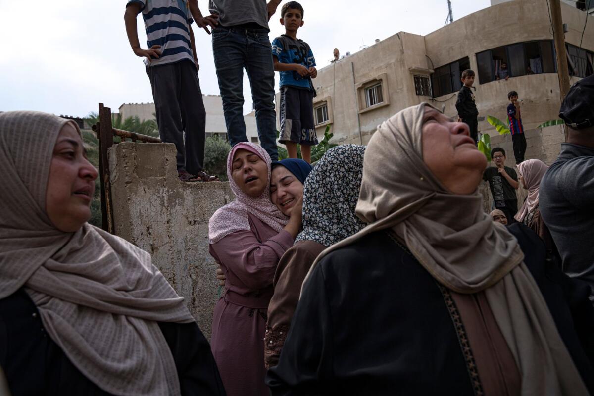 Relatives mourn people killed in an Israeli air strike in Gaza City. — AP