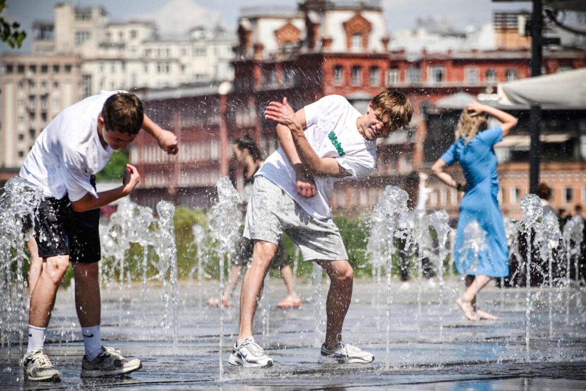 Youths refresh themselves in a fountain in central Moscow during midday heat. — Photo: AFP file