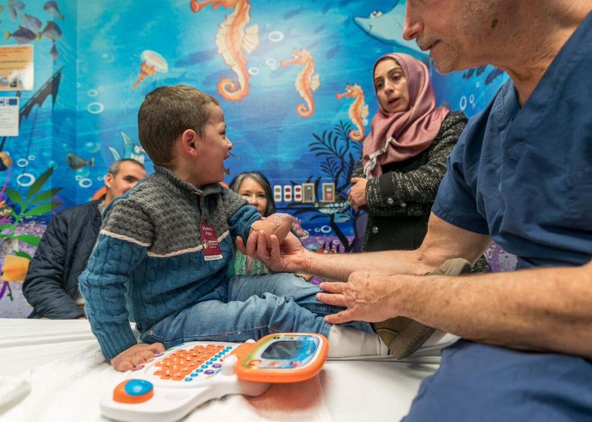 Four-year-old Omar Abu Kuwaik cries as orthopedic surgeon Dr Scott Kozin examines his arm at Shriners Children's Hospital, on Jan. 18, 2024, in Philadelphia. — AP