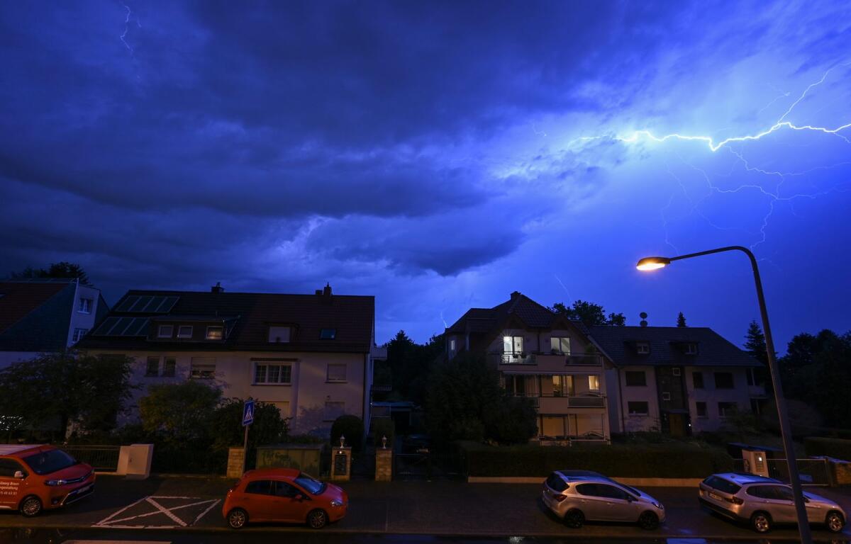 Lightning discharges in the evening sky during a heavy thunderstorm over the houses in the district of Sachsenhausen, Frankfurt/Main, Germany, on Wednesday, -- AP