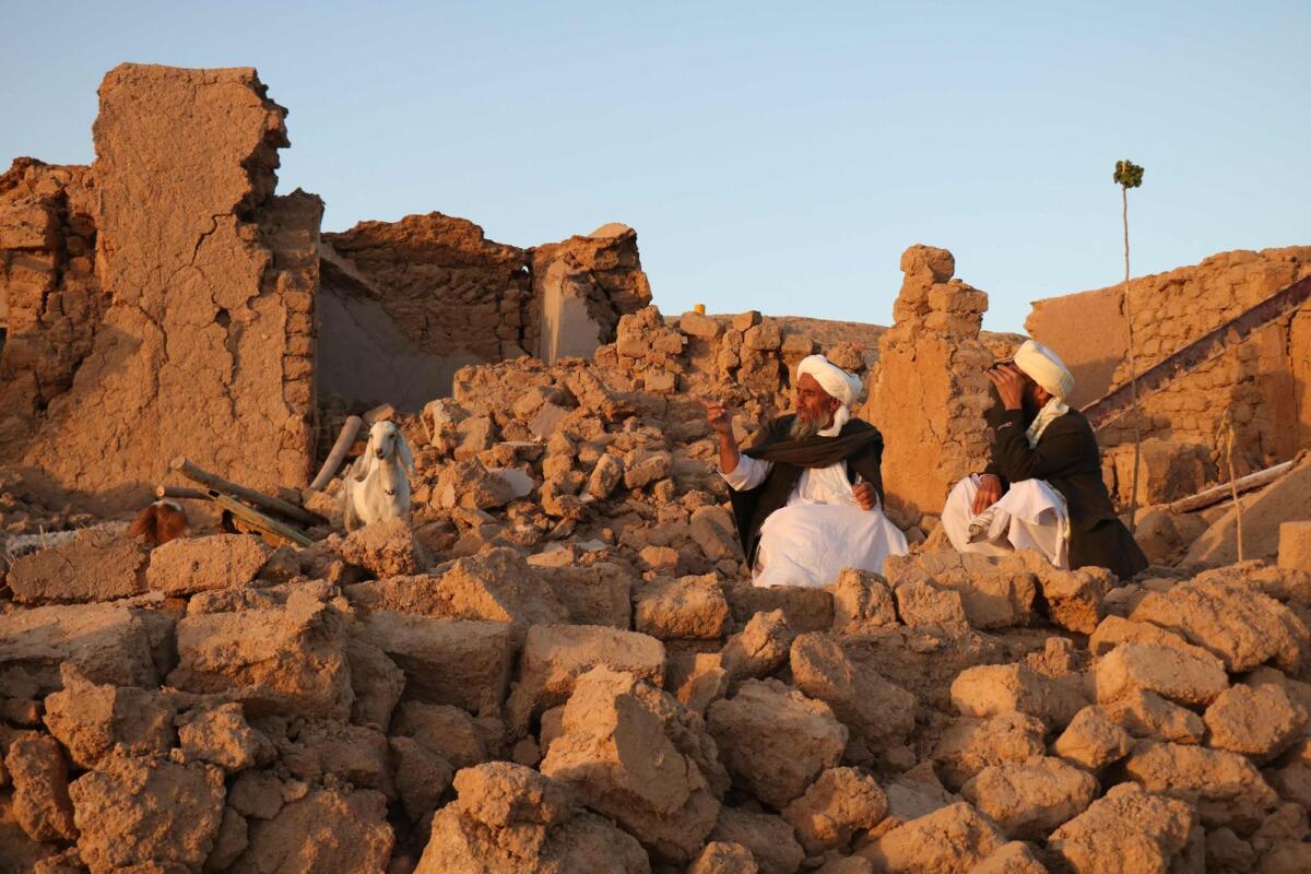 Afghan residents sit at a damaged house after earthquake in Sarbuland village of Zendeh Jan, district of Herat province, on October 7,2023. Photo: AFP