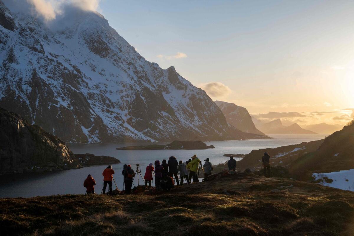 (Tourists from China photograph a fjord in Unstad on Lofoten Islands, on March 2, 2023.  — AFP