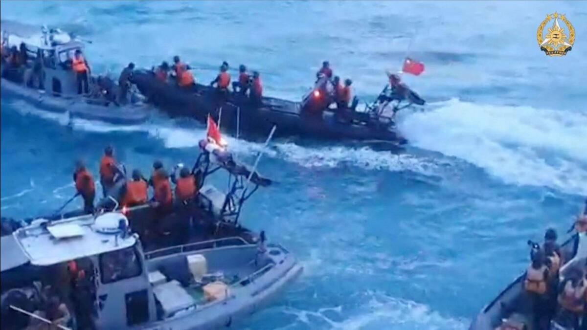 A frame grab from a video footage released on June 25 by the Armed Forces of the Philippines shows Chinese Coast Guard personnel aboard inflatable boats (in black) during a confrontation with Philippine Navy personnel in the disputed waters of the South China Sea. — AFP