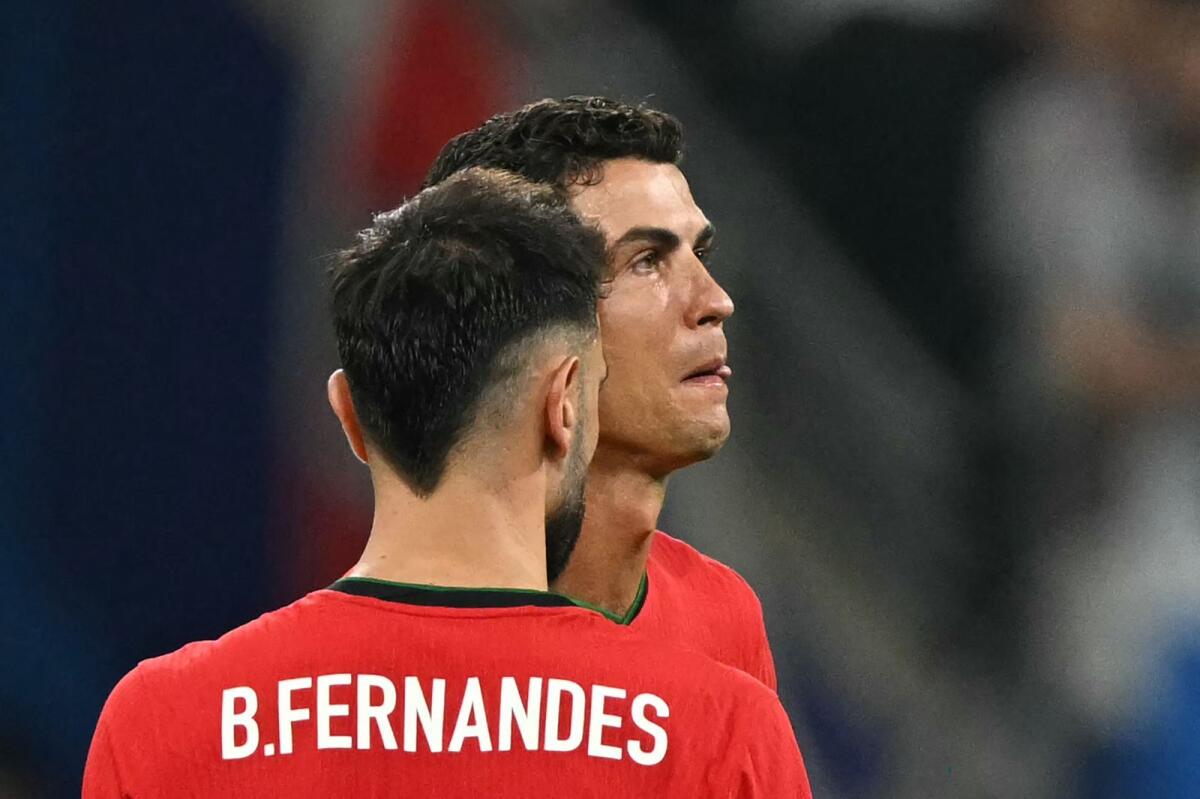 Portugal's forward Cristiano Ronaldo (right) reacts after failing to score from a penalty kick against Slovenia. — AFP