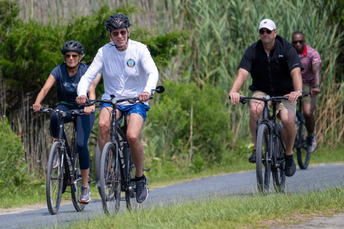 US President Joe Biden (2nd L) and First Lady Jill Biden (L) ride their bikes through Gordons Pond State Park in Rehoboth Beach, Delaware, on August 1, 2023. Photo: AFP