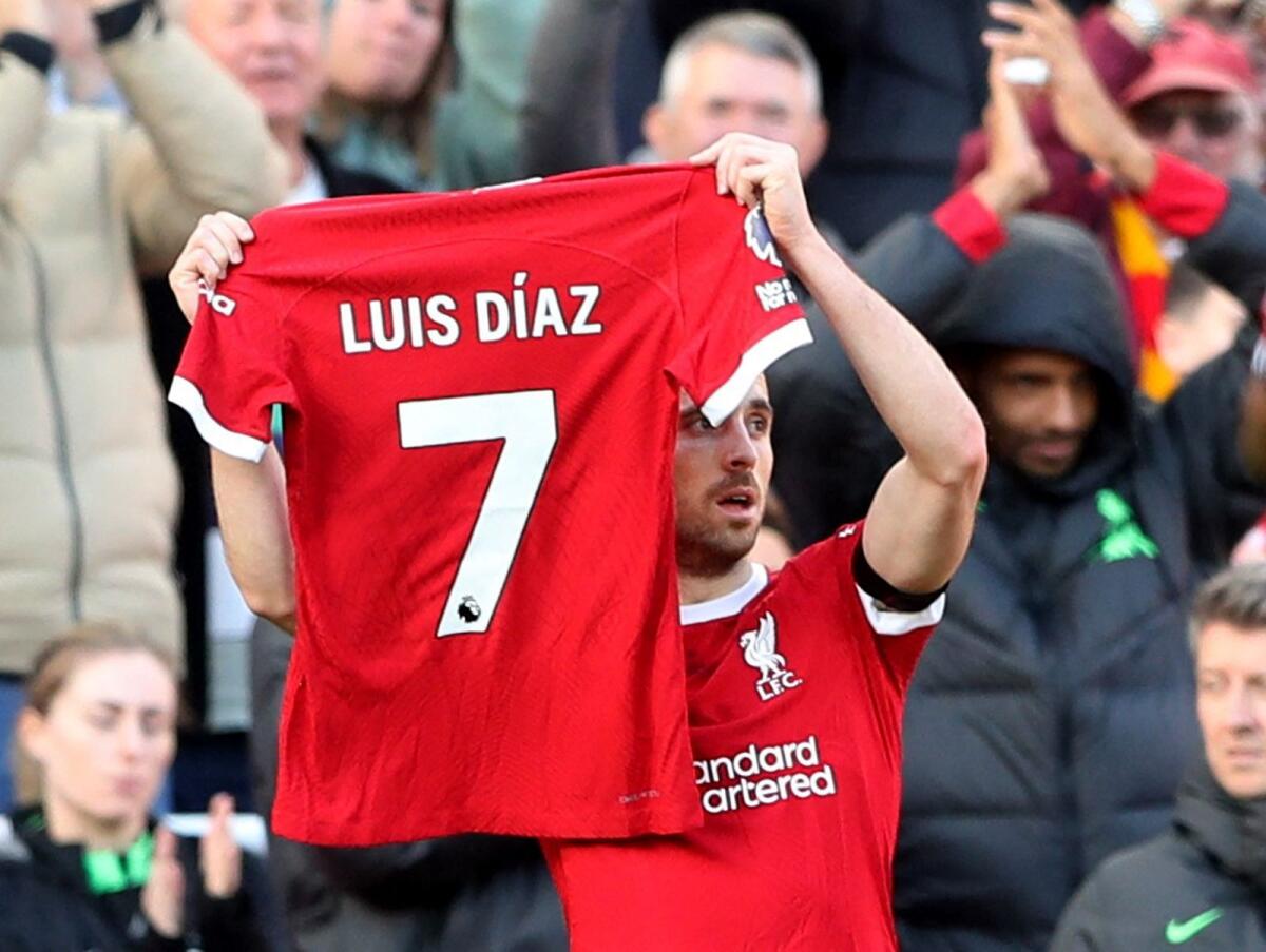 Liverpool's Diogo Jota holds up a shirt in support of Luis Diaz after scoring a goal on Sunday. — Reuters