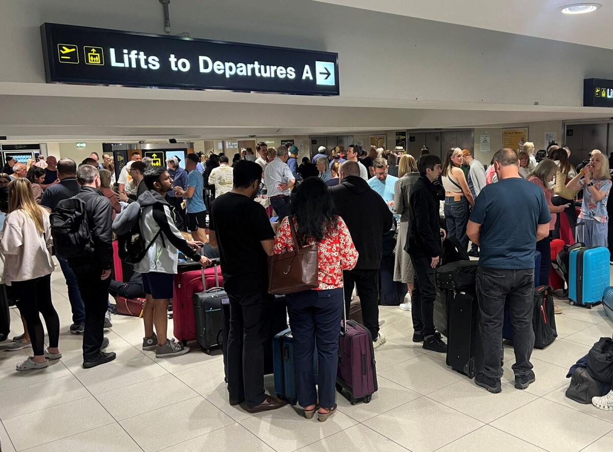 Passengers queue outside Terminal 1 after an overnight power cut led to disruptions and cancellations at Manchester Airport in Manchester, Britain, June 23, 2024. Photo: Reuters