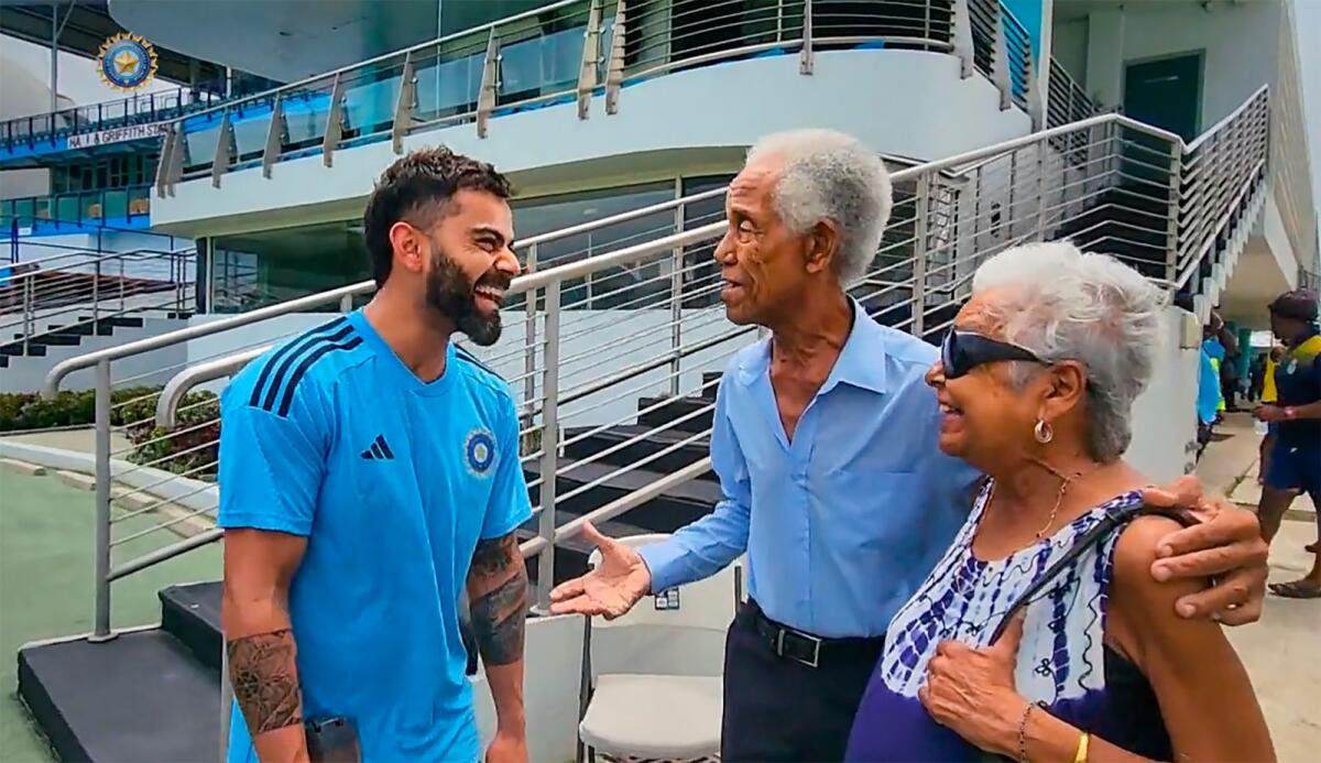 Indian cricketer Virat Kohli meets legendary West Indies cricketer Garfield Sobers, 86, and his wife, Pru Kirby, during a training session, in Barbados. - PTI