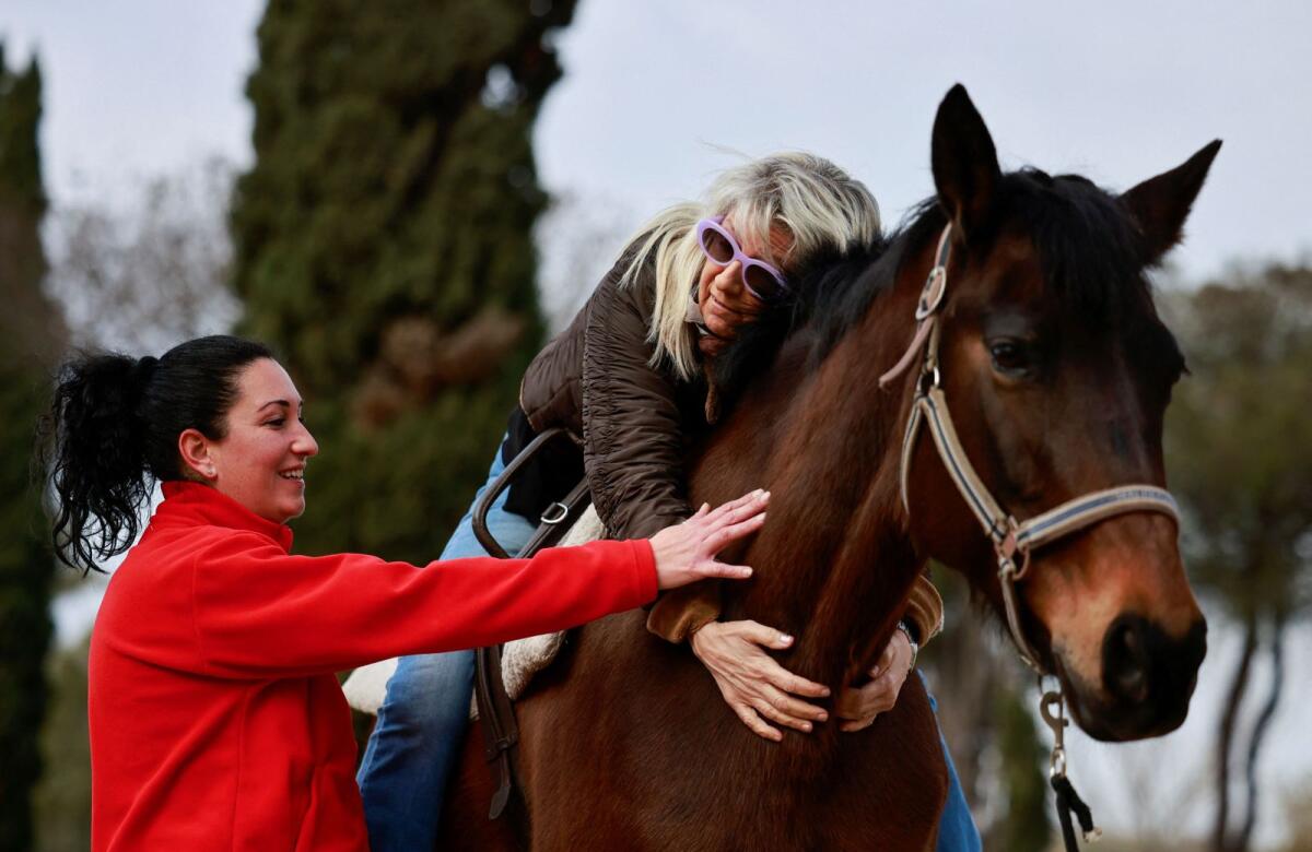 Parkinson's disease patient Giuliana Geatti attends a hippotherapy session with her physiotherapist Sabrina Valente at San Giovanni Battista Hospital in Rome. — Reuters