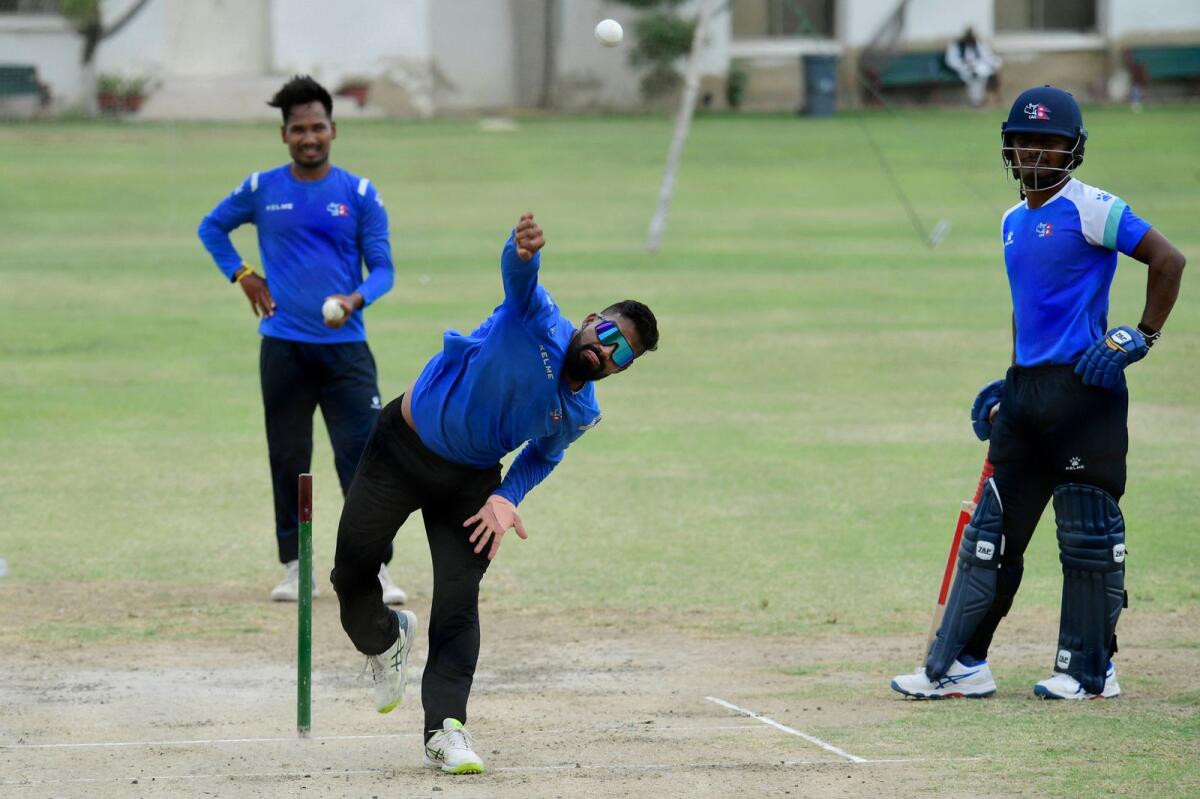 Dipendra Singh Airee (centre) bowls during a practice session. — AFP
