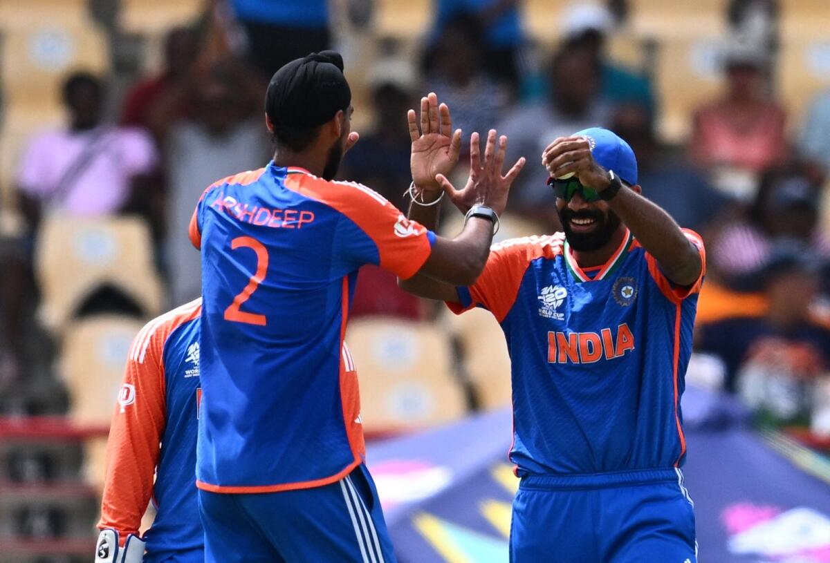 India's Jasprit Bumrah (R) celebrates with India's Arshdeep Singh after catching out Australia's Tim David during the ICC men's Twenty20 World Cup. Photo: AFP