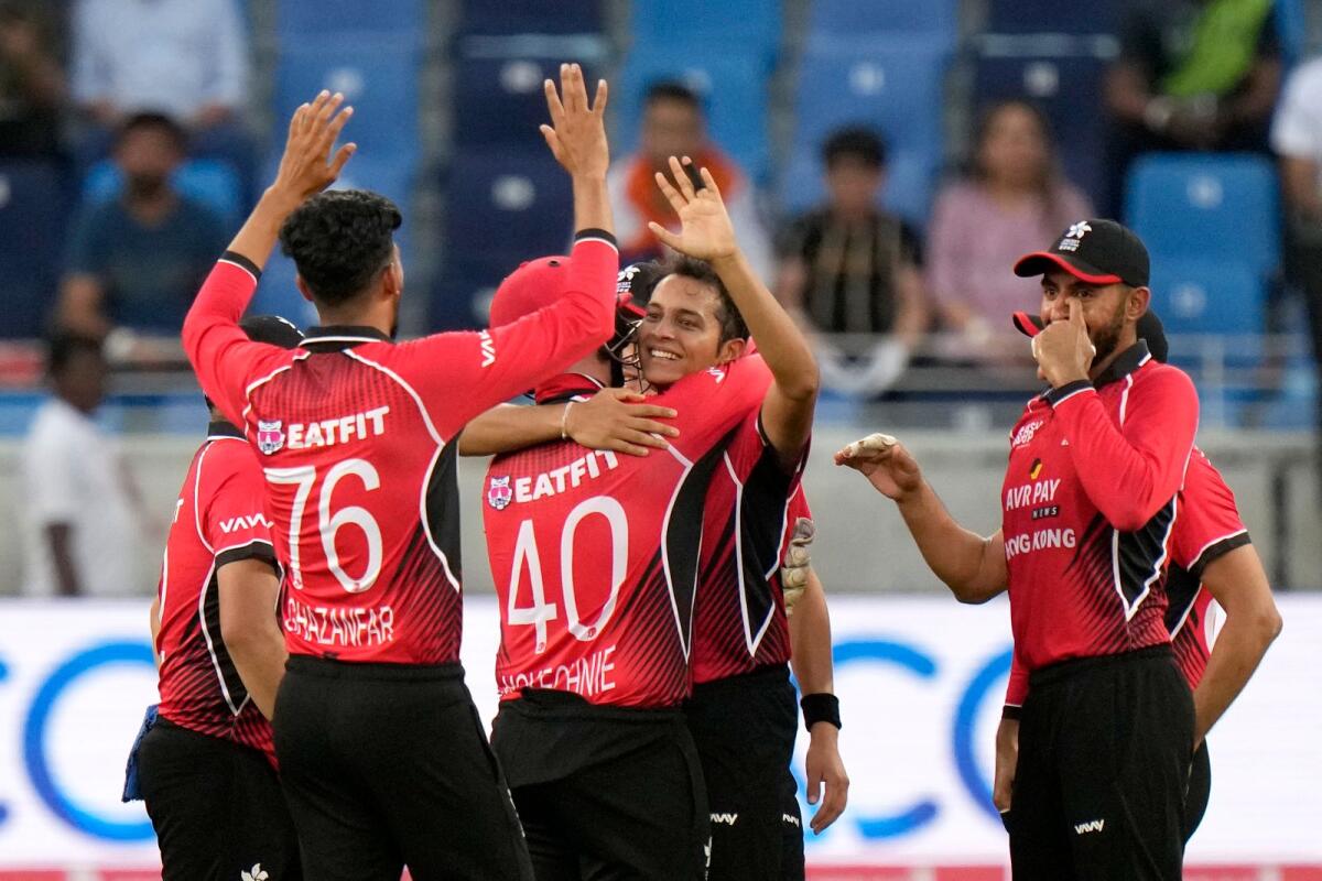 Hong Kong's Ayush Shukla (centre) celebrates with teammates after taking the wicket of India's Rohit Sharma. (AP)