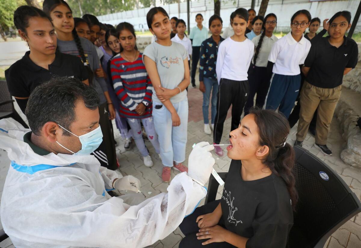 A healthcare worker collects sample of an NCC cadet for Covid-19 test on the first day of a 10-day NCC camp at Nagrota on the outskirts of Jammu on April 27, 2023. Photo: PTI