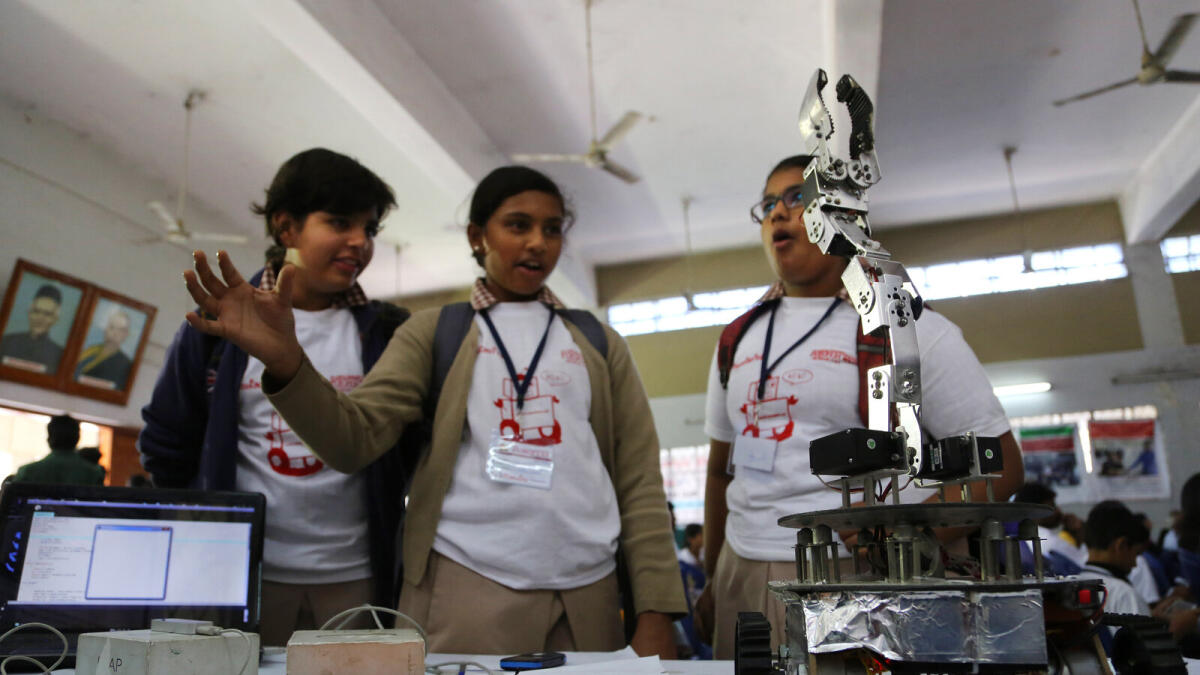 A student gestures with her hand to control a robotic arm at the ‘Robotic Festival 2016’ in Bengaluru, India. 