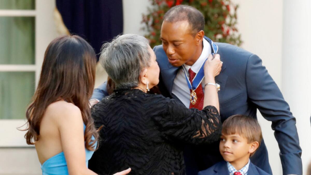 Tiger Woods is embraced by his mother Kultida Woods after being presented with the Presidential Medal of Freedom, the nation's highest civilian honour, as his girlfriend Erica Herman and his son Charlie look on. (Reuters file)