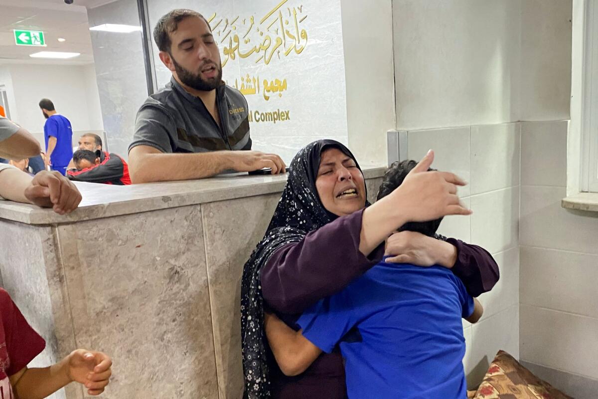 The mother of Palestinian Mohammed Abu Amira, who was killed in an Israeli strike, is comforted by her son as she breaks down at Al Shifa hospital in Gaza City on November 9. — Reuters