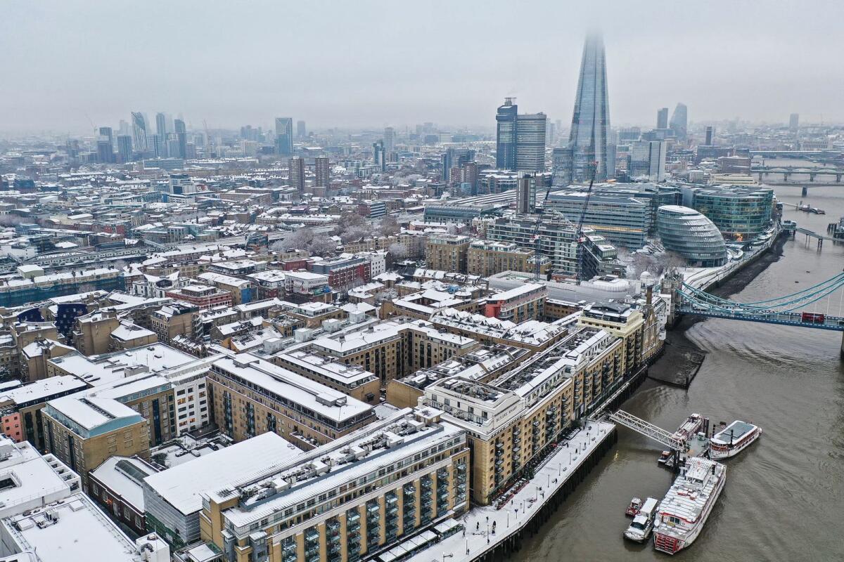 An aerial view shows snow-covered offices and buildings including the Shard skyscraper on the south bank of the River Thames, from Wapping, east London on December 12, 2022. Photo: AFP