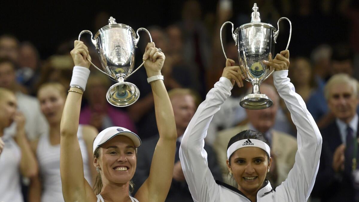 Martina Hingis of Switzerland and Sania Mirza of India pose with their trophies after winning their Women's Doubles Final match