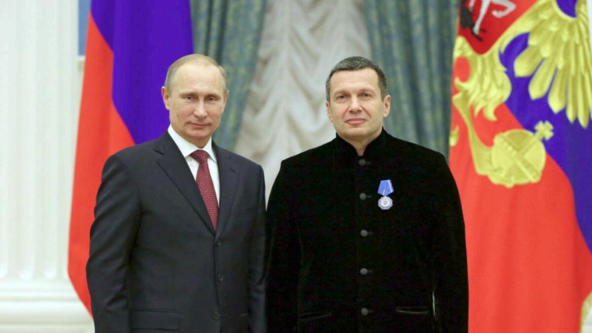 Russian President Vladimir Putin with TV anchor Vladimir Solovyov. — AFP