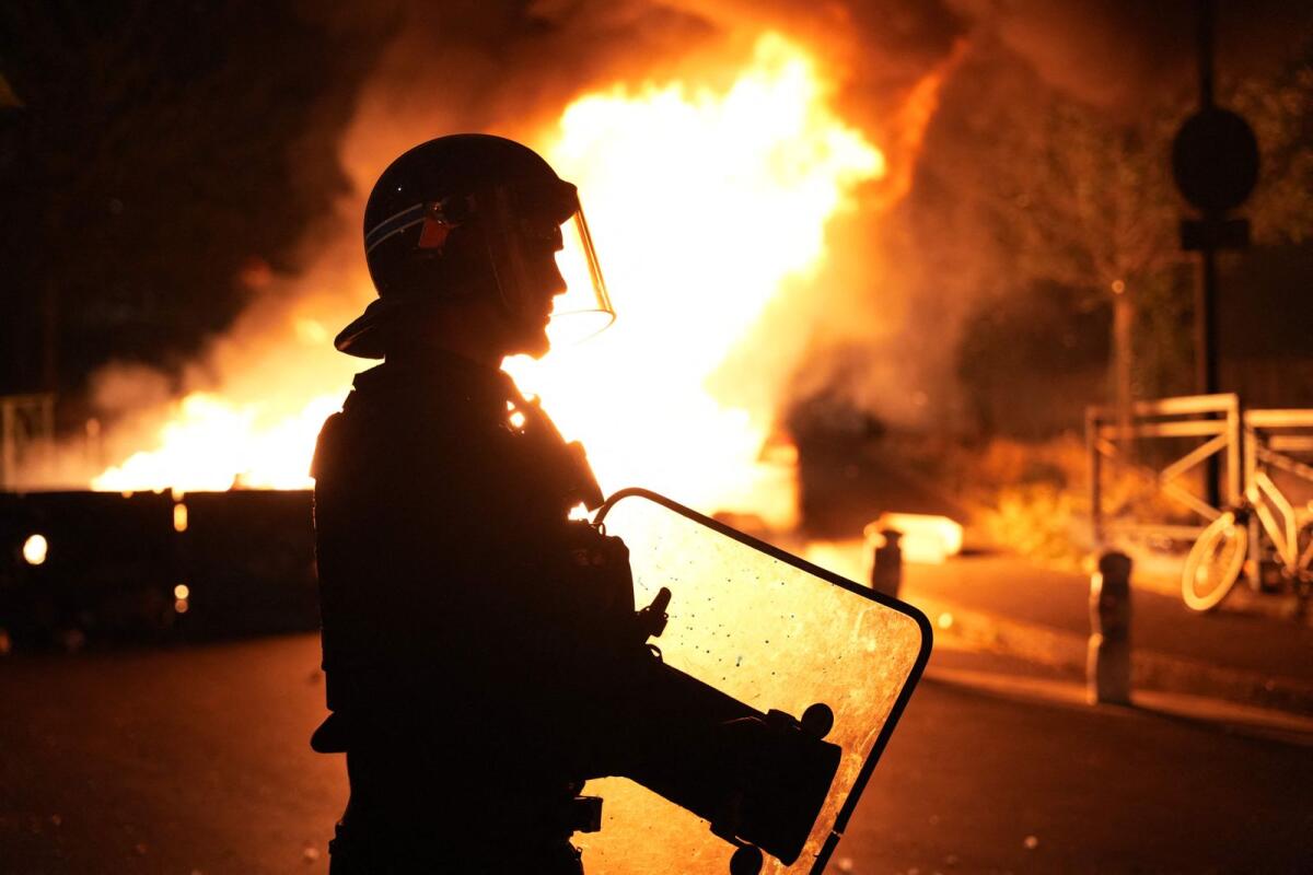 A firefighter looks on as vehicles burn following riots in Nanterre, west of Paris, on June 28, 2023. Photo: AFP