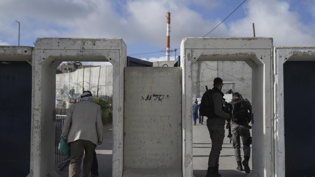 Palestinians cross from the Israeli military Qalandia checkpoint near the West Bank city of Ramallah to Jerusalem. — AP