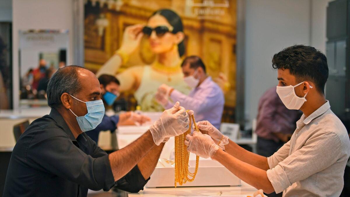 Men handle jewellery at a jeweller's shop at the Dubai Gold Souk. Gold price felt the pull of gravity once again, reverting to 29-month lows of $1,654 on On Thursday. — File photo